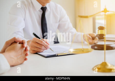 Recht und Gesetz Konzept. Rechtsberater präsentiert auf dem Client einen unterzeichneten Vertrag mit Hammer und rechtlichen gesetzlichen Bestimmungen oder in Team treffen in Anwaltskanzlei in b Stockfoto