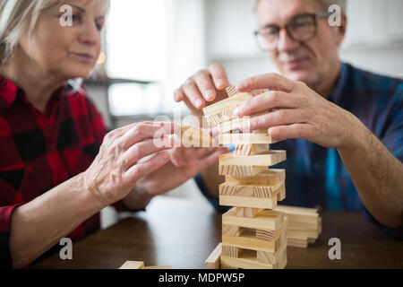 Portrait von Senior Paar am Tisch spielen Jenga sitzen Stockfoto