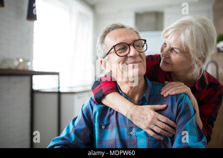 Portrait von gerne ältere Frau ihren Ehemann umarmen Stockfoto