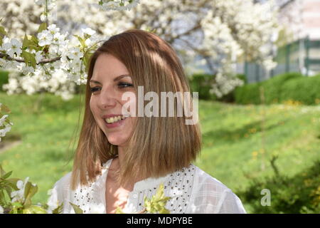 Junge Frau mit cherry tree Posing Stockfoto