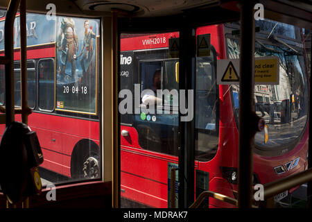 Die tätowierte Arm von einem Busfahrer und eine Anzeige für eine neue Playstation Spiel "der Gott des Krieges, am 19. April 2018 in London, England. Stockfoto