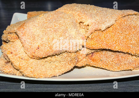 Frisch gebackene raw Kalbsschnitzel auf einem weißen Teller. Stockfoto