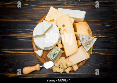 Verschiedene Arten von Käse-Brie, Camembert, Roquefort und Cheddar auf Holzbrett Stockfoto