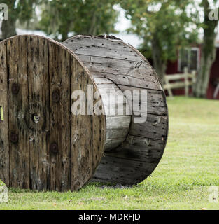 Eine große Alte, leere Holz- Kabel-Spool auf Gras. Stockfoto