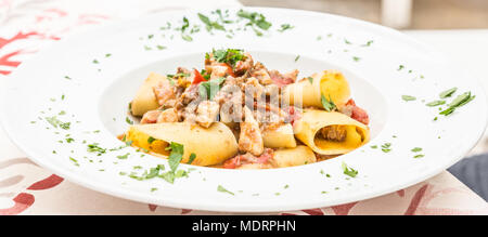 Otranto Stadt, Region Apulien, im Süden von Italien. Traditionelle Paccheri Pasta mit Schwertfisch, serviert mit Tomaten, Petersilie, Olivenöl. Tageslicht, echten Res Stockfoto