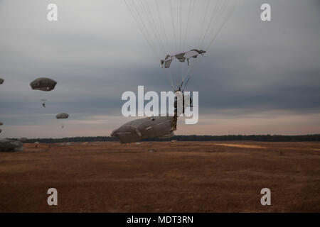 Operation Toy Drop ist eine jährliche Luftlandeoperation des U.S. Army Civil Affairs & Psychological Operations Command (Airborne). Das Archivbild dokumentiert Fallschirmjäger, die am 2. Dezember 2017 eine koordinierte Fallschirmabfahrt über der Sicily Drop Zone in Fort Bragg, North Carolina, durchgeführt haben. Stockfoto