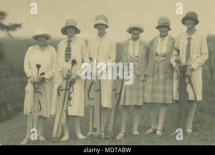 Golfspieler am links in Atherton ca 1925. Lage: Atherton, Queensland Beschreibung: Junge Frauen mit cloche Hüte, Röcke und Jacken. Jede hat ihren eigenen Satz von Golf Clubs. Stockfoto