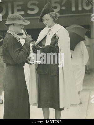 Rennstrecke Moden auf dem Feld am Doomben, Brisbane, ca 1945. Lage:, Brisbane, Queensland, Australien Datum: Undatiert. Ca. 1935 Beschreibung: zwei Damen, die das Studium der Form Guides sind sowohl elegant gekleidet. Stockfoto