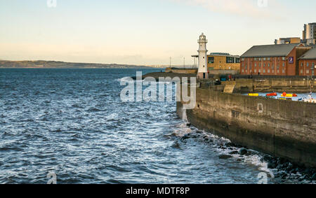 Newhaven Hafen, Edinburgh, Schottland, Vereinigtes Königreich, 7. Dezember 2017. Ein windiger Tag am Ende der Sturm Caroline schafft Wellengang auf der Hafenmauer Stockfoto