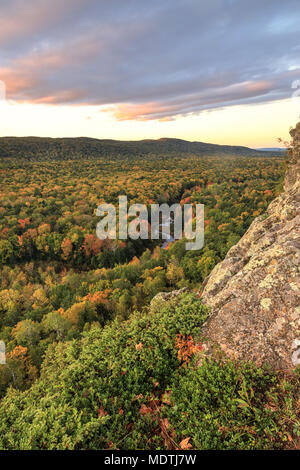 Die großen Karpfen Fluss schneidet eine Schwade durch einen farbigen Herbst Wald. Von einem Felsvorsprung auf einem Wanderweg an Porcupine Mountains Wilderness Area gesehen, Stockfoto