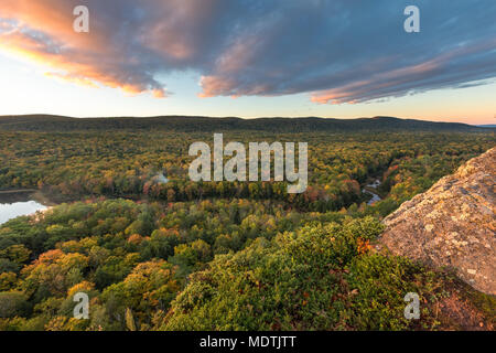 Die großen Karpfen Fluss schneidet eine Schwade durch einen farbigen Herbst Wald. Von einem Felsvorsprung auf einem Wanderweg an Porcupine Mountains Wilderness Area gesehen, Stockfoto