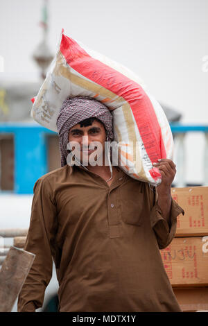 Arbeiter entladen Säcke aus einer Dhow entlang des Dubai Creek, Deira, Dubai, Vereinigte Arabische Emirate, Naher Osten günstig Stockfoto
