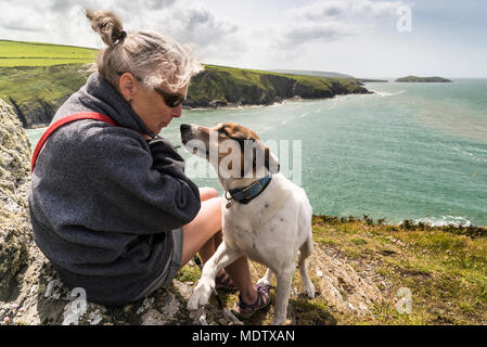 Spaziergang mit dem Hund auf Foel y Mwnt mit Ceredigion Küste und Cardigan Bay im Hintergrund Stockfoto