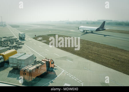 Ein passagierflugzeug von Ground Services gewartet wird vor dem nächsten Start. pushback Schlepper, Passenger Boarding Schritte Fahrzeug, Traktor mit gepäckwagen ein Stockfoto