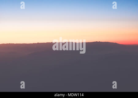 Die Natur in der Dämmerung, Sonnenaufgang oder Sonnenuntergang über den Berg. Bergblick aus tropischen High Peak mit violetten Himmel. Sommer Saison mit blauen und pur Stockfoto