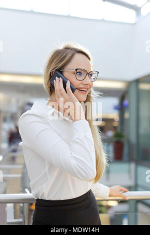 Junge blonde kaukasischen Geschäftsfrau Aufruf im Business Center Stockfoto
