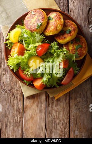 Frisch zubereitet Kartoffelpuffer mit frischem Salat in der Nähe serviert auf einem Teller. Vertikal oben Ansicht von oben Stockfoto