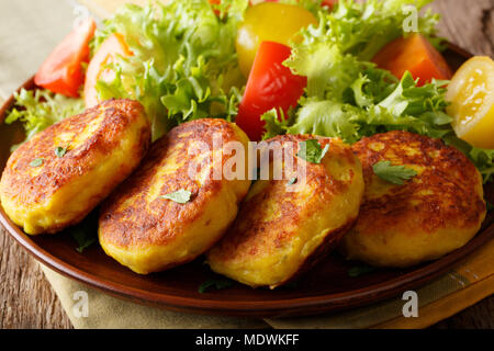 Frisch zubereitet Kartoffelpuffer mit frischem Salat in der Nähe serviert auf einem Teller. Horizontale Stockfoto