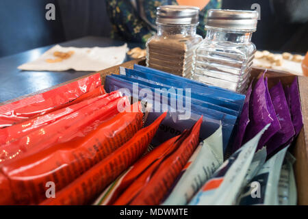 Salz, Pfeffer und Beutel von Sauce in einem Fach auf einen Tisch. Stockfoto