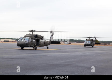 UH-60 Blackhawks warten Fallschirmjäger bei der 20. jährlichen Randy Oler Memorial Betrieb Spielzeug Drop zu laden, bei MacKall Army Airfield, Nord-Carolina, Dez. 7, 2017. Dieses Jahr, acht Länder beteiligt sind und sie gehören; Kolumbien, Kanada, Lettland, den Niederlanden, Schweden, Italien, Deutschland und Polen. Betrieb Spielzeug Fallen, bewirtet durch die US-Armee die zivilen Angelegenheiten & psychologische Operations Command (Airborne) ist die größte kombinierte Betrieb weltweit durchgeführt. Die Veranstaltung der Soldaten erlaubt, die Möglichkeit, auf ihren militärischen beruflichen Spezialgebiet zu trainieren, ihre zerstreuten readine beibehalten Stockfoto