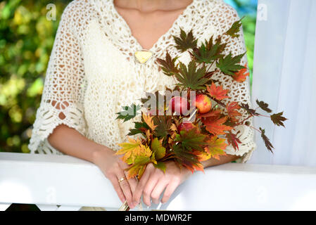 Herbst Ahorn Blätter und Äpfel in womans Hände Stockfoto