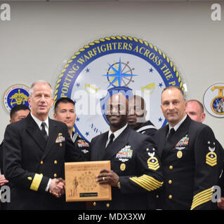 171214-N-KR 394-079 SAN DIEGO, Kalifornien (31. 14, 2017) CMDCM Dennis Hathorn, Command Master Chief für U.S. Naval Hospital Okinawa (vorne Mitte), nimmt eine Plakette im Auftrag der Marine 2017 Medizin West blaue Jacke des Jahres, Hospitalman Vanessa Delacruz. Hintere Adm. Paul Pearigen (vorne links), Commander, Marine Medizin West (Nmw) und Chef der Marine Medical Corps, und CMCDCM Loren Rucker, Command Master Chief für Marine Medizin West (vorne rechts), überreichte den Preis in einem Konferenzraum mit Matrosen und ziviles Personal verpackt aus der gesamten Region. Stockfoto