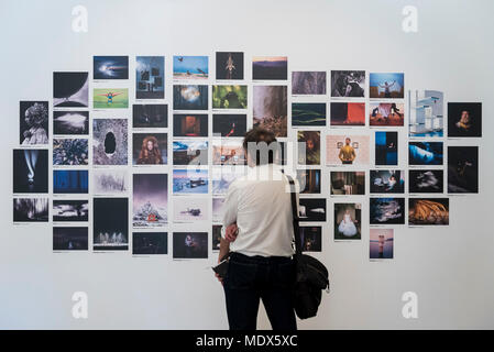 London, Großbritannien. 20. April 2018. Ein Besucher eine Montage von Bildern von den Sony World Photography Awards 2018 Ausstellung im Somerset House. Die 11. Ausgabe des Wettbewerbs sah 320 000 Einreichungen aus über 200 Ländern. Die Ausstellung läuft vom 20. April bis 6. Mai. Credit: Stephen Chung/Alamy leben Nachrichten Stockfoto