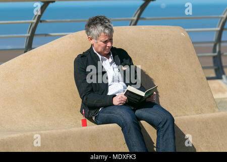 Buchleser genießen das warme Aprilwetter in Blackpool, Lancashire. UK Wetter an der Fylde-Küste beginnt der Tag sonnig, da die Nordwestküste in dieser Woche die bisher heißesten Temperaturen erlebt. Quelle: MediaWorldImages/AlamyLiveNews Stockfoto