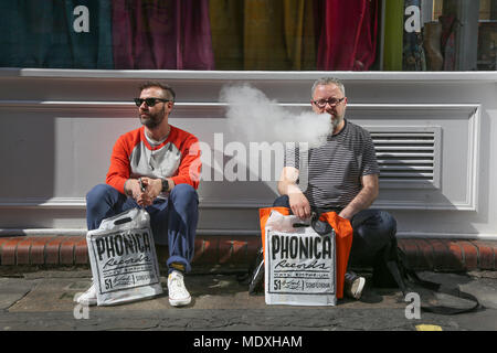 London, Großbritannien. 21. April 2018. Zwei Männer sitzen auf Pflaster mit Käufen von Record Shop jim Forrest @ alamy live news Credit: Jim Forrest/Alamy leben Nachrichten Stockfoto