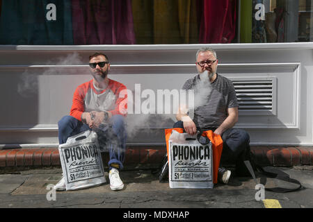 London, Großbritannien. 21. April 2018. Zwei Männer sitzen auf Pflaster mit Käufen von Record Shop jim Forrest @ alamy live news Credit: Jim Forrest/Alamy leben Nachrichten Stockfoto
