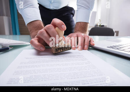 In der Nähe von einem Geschäftsmann Hand Stanzen am Dokument in Office Stockfoto