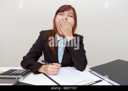 Geschäftsfrau gähnen oder schläfrig fühlen bei der Arbeit im Büro nach dem Starten Stockfoto