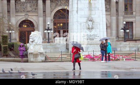 Nass und regnerisch Ehrenmal war Memorial roten Mantel Regenschirm Einheimische und Touristen vor Ort Kammern, George Square, Glasgow, Großbritannien Stockfoto