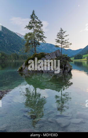 Rock Island mit Bäumen am Hintersee und Berge in der Morgendämmerung in Ramsau, Nationalpark Berchtesgaden in Oberbayern, Deutschland Stockfoto