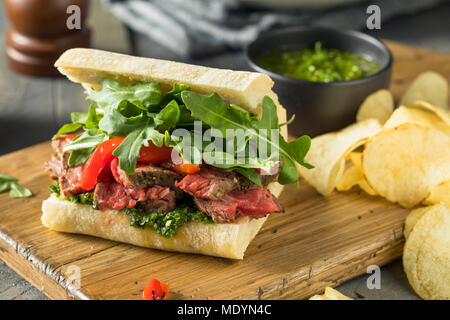 Hausgemachtes Rindfleisch Steak Sandwich mit Chimichurri und Rucola Stockfoto
