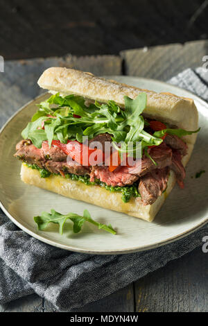 Hausgemachtes Rindfleisch Steak Sandwich mit Chimichurri und Rucola Stockfoto