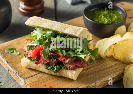 Hausgemachtes Rindfleisch Steak Sandwich mit Chimichurri und Rucola Stockfoto
