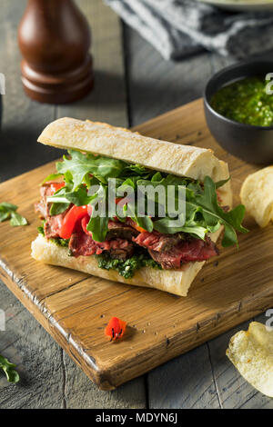 Hausgemachtes Rindfleisch Steak Sandwich mit Chimichurri und Rucola Stockfoto