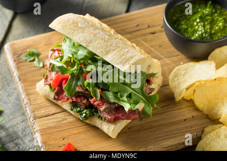 Hausgemachtes Rindfleisch Steak Sandwich mit Chimichurri und Rucola Stockfoto
