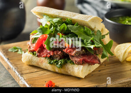 Hausgemachtes Rindfleisch Steak Sandwich mit Chimichurri und Rucola Stockfoto