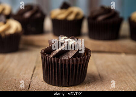 Held chocolate Cupcake auf hölzernen Tisch Stockfoto