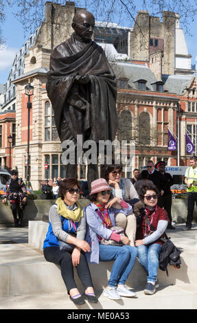 Japanische Touristen für Fotografie an der Mahatma Gandhi Statue in London's Parliament Square posiert Stockfoto