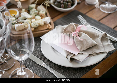 Girlande aus Blumen und Grün für die Tischdekoration. Luxus Hochzeit im Restaurant. Stilvolle Einrichtung und schmücken. Weiße Kerzen auf Glas candl Stockfoto