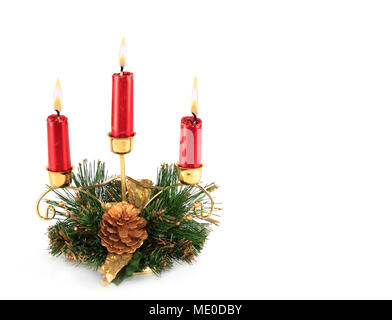 Drei brennende Rote Kerzen in Weihnachten themed dekoriert Messing Kerzenhalter Tischdekoration Stockfoto