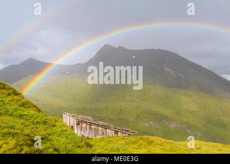 Regenbogen über Berglandschaft mit Hütte bei Kaiser Franz Josefs Hohe im Nationalpark Hohe Tauern in Kärnten, Österreich Stockfoto