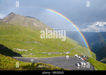 Regenbogen über Berglandschaft mit Parkplatz bei Kaiser Franz Josefs Hohe im Nationalpark Hohe Tauern in Kärnten, Österreich Stockfoto