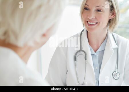 Ärztin lächelnd zum Patienten. Stockfoto