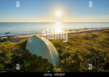 Kleines Boot auf dem Kopf am Strand bei Sonnenuntergang im Sommer bei Sealand Odde in Odsherred an der Ostsee in Seeland, Dänemark Stockfoto