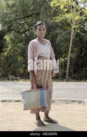 Eine Frau, die mit einem gewebten Beutel auf den Markt geht, Bagan, Myanmar Stockfoto