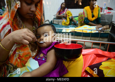 Bangladesch eine Mutter ihre Kinder füttern Kochsalzlösung, leidet an Durchfall liegen im Internationalen Zentrum für Durchfall Erkrankung Forschung, Banglad Stockfoto